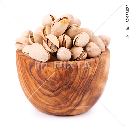Pistachio nuts, isolated in olive bowl, on white background. Salted roasted pistachios. Pistachio nuts, isolated in olive bowl, on white background. Salted roasted pistachios. 82478825