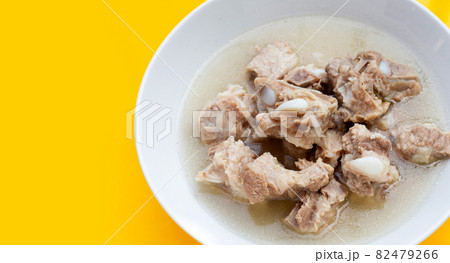 Boiled pork ribs in white bowl on yellow background. Boiled pork ribs in white bowl on yellow background. 82479266