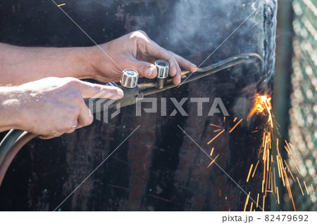 Worker cuts and brews black metal close-up shot Worker cuts and brews black metal close-up shot 82479692
