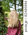 Woman taking pictures with smartphone in the forest 82480994