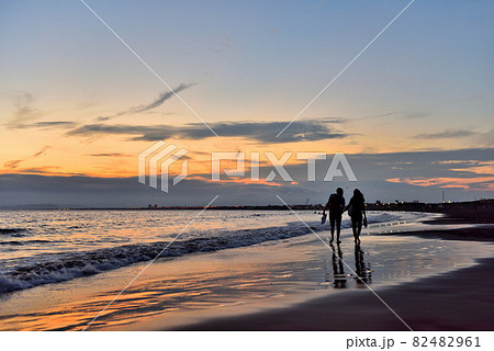夕焼けの片瀬西浜海岸を散歩する二人 82482961