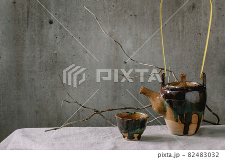 Kettle with cup of hot green tea 82483032