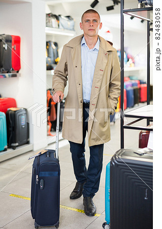 Portrait of a respectable man with a suitcase after shopping in haberdashery store 82483058