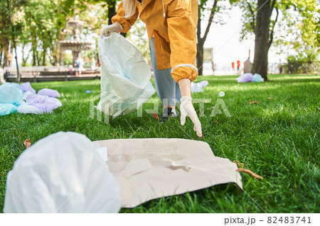 Active environmentalist wearing protective gloves cleaning the park Active environmentalist wearing protective gloves cleaning the park 82483741