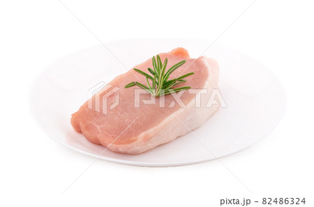 Raw pork in white plate on dark background Raw pork in white plate on dark background 82486324