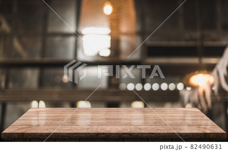 Empty wooden table top with lights bokeh on blur restaurant background 82490631