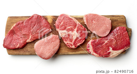Various types of steak on wooden board isolated on white, from above 82490716