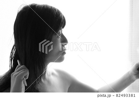 鏡を見て髪をいじる女性 鏡を見て髪をいじる女性 82493381