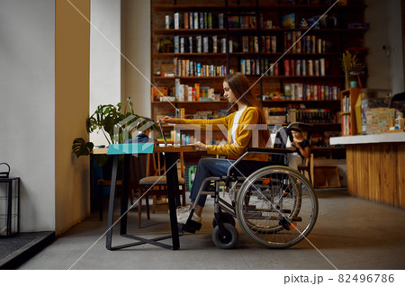 Disabled female student in wheelchair using laptop Disabled female student in wheelchair using laptop 82496786