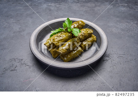 Delicious stuffed grape leaves dolma with parsley in black plate 82497235