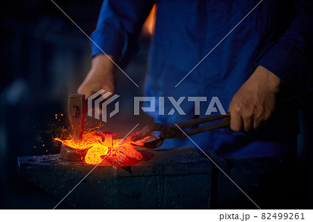 Man using pliers and hammer while working with molten metal Man using pliers and hammer while working with molten metal 82499261