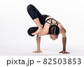 Beautiful sporty woman doing advanced yoga practice on white bac 82503853