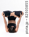 Beautiful sporty woman doing advanced yoga practice on white bac 82503855