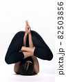 Beautiful sporty woman doing advanced yoga practice on white bac 82503856