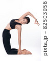 Beautiful sporty woman doing advanced yoga practice on white bac 82503956