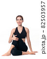 Beautiful sporty woman doing advanced yoga practice on white bac 82503957