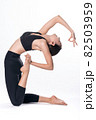 Beautiful sporty woman doing advanced yoga practice on white bac 82503959