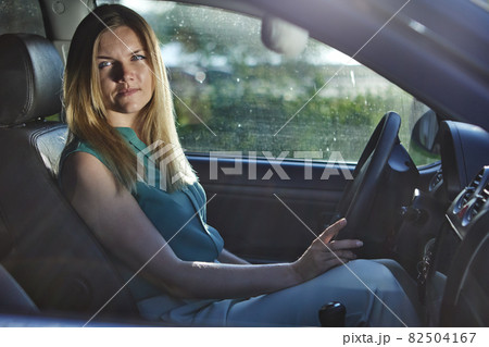Young european woman with blond hair is driving car. Young european woman with blond hair is driving car. 82504167