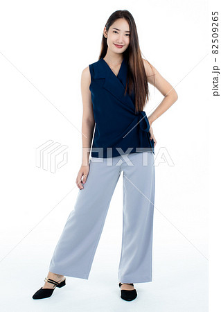 Full body shot of cute delighted young Asian woman smiling and looking at camera isolated on while background. 82509265