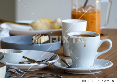 stacks of dirty dishes, plates and cups of finished meal in christmas or new year party waiting to clean at the dining room in house or restaurant 82509310