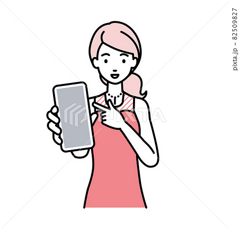 立ってスマートフォンを指差してこちらに向けて見せているドレスの女性 82509827
