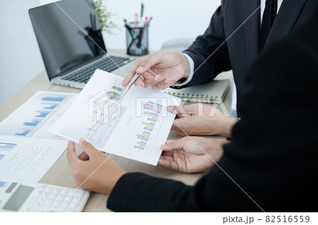 Two business leaders talk about charts, financial graphs showing results are analyzing and calculating planning strategies, business success building processes Two business leaders talk about charts, financial graphs showing results are analyzing and calculating planning strategies, business success building processes 82516559