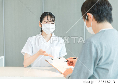 受付にいる看護師と患者（マスク） 82518213