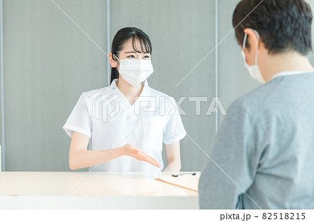 受付にいる看護師と患者（マスク） 82518215