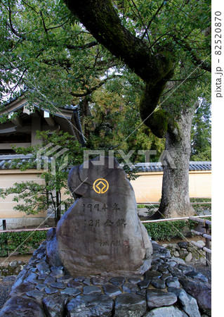 薄っすらと雪が積もった金閣寺入口前の庭園　の世界遺産を示す石碑　登録年月の記載有り　縦位置 82520870