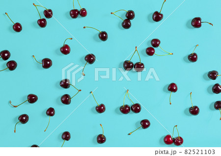 Fresh juicy cherries on mint background, top view Fresh juicy cherries on mint background, top view 82521103