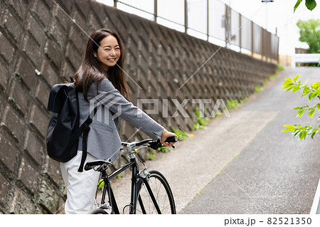 笑顔で振り向く女性 自転車の通勤イメージの写真素材