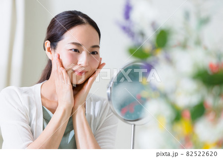 鏡を見てスキンケアをする女性（ビューティーイメージ） 82522620