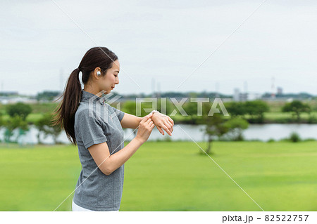 スマートウォッチを見てランニングをする女性（音声操作） 82522757