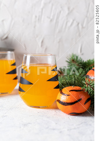 orange mandarin cocktail in glass with black stripes. Christmas holiday welcome drink. Concept for children new year 82525605