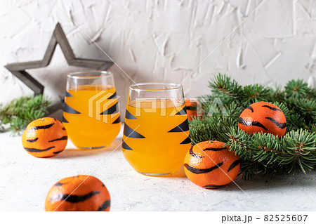 orange mandarin cocktail in glass with black stripes. Christmas holiday welcome drink. Concept for children new year 82525607