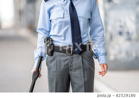 policeman with a baton on a city street policeman with a baton on a city street 82529180