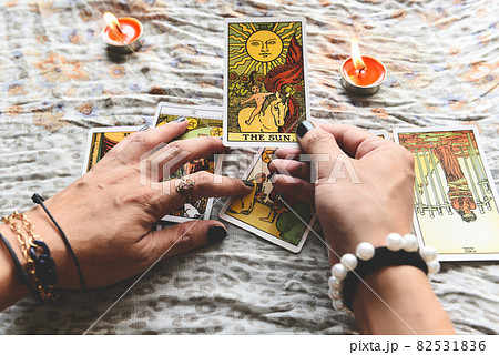 Show fortune tellers of hands holding tarot cards and tarot reader with candle light on the table, Performing readings magical performances, Things mystical astrologists forecasting concept Show fortune tellers of hands holding tarot cards and tarot reader with candle light on the table, Performing readings magical performances, Things mystical astrologists forecasting concept 82531836