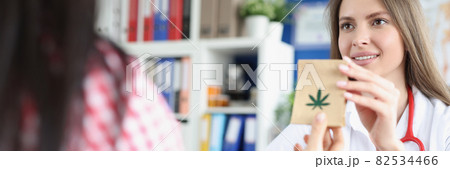 Female doctor handing over packet of marijuana to patient Female doctor handing over packet of marijuana to patient 82534466