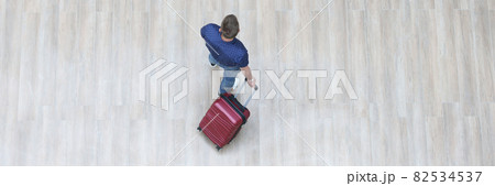 Male tourist walking with suitcase top view Male tourist walking with suitcase top view 82534537