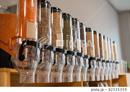A woman fills a jar with red lentils. Selling bulk goods by weight in an eco store. Trade concept without plastic packaging 82535359