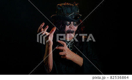 Frightening senior woman with Halloween witch makeup listening music, smiling dancing to disco music Frightening senior woman with Halloween witch makeup listening music, smiling dancing to disco music 82536864
