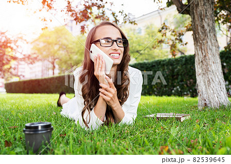 woman in the park with phone woman in the park with phone 82539645