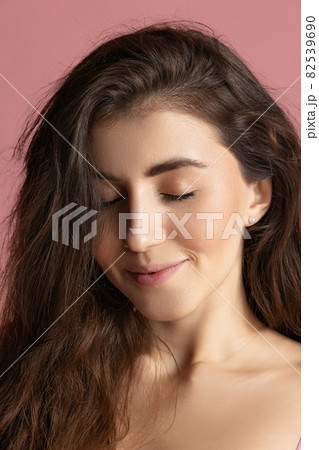 Close-up portrait of young beautiful girl without makeup isolated over pink studio background. Natural beauty concept. Close-up portrait of young beautiful girl without makeup isolated over pink studio background. Natural beauty concept. 82539690