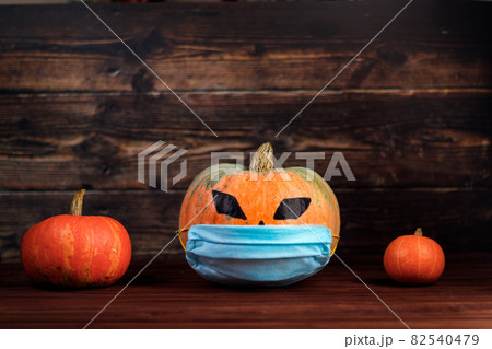 Halloween 2020. Pumpkin with a protective medical face mask. Holiday and coronavirus concept. Halloween 2020. Pumpkin with a protective medical face mask. Holiday and coronavirus concept. 82540479
