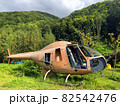 Abandoned damaged helicopter in center forest in mid of Carpathian Mountains. Disused rusty chopper without doors and wings is nothing but aged scrap of old vehicle among green nature of Carpathians 82542476