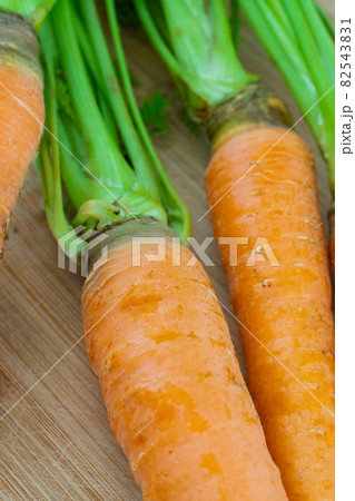 fresh orange carrot with tops close-up spring harvest fresh orange carrot with tops close-up spring harvest 82543831