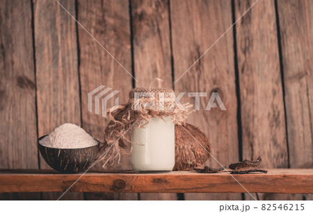 Coconut shavings and coconut oil on black background. Coconut with coconut flakes Coconut shavings and coconut oil on black background. Coconut with coconut flakes 82546215