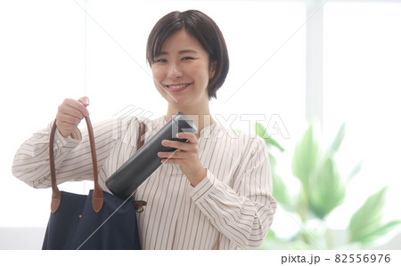 鞄から水筒を取り出す女性 82556976
