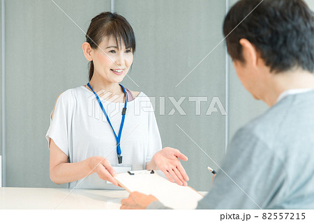 スポーツジムの受付をする女性(記入) スポーツジムの受付をする女性(記入) 82557215