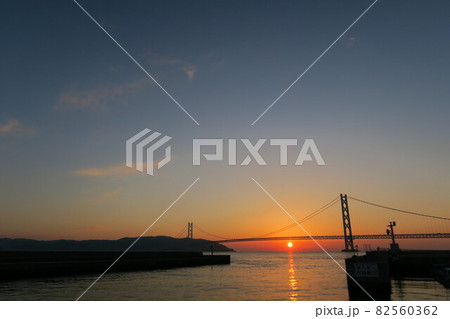 神戸フィッシャリーナから見た明石海峡大橋と夕日 82560362